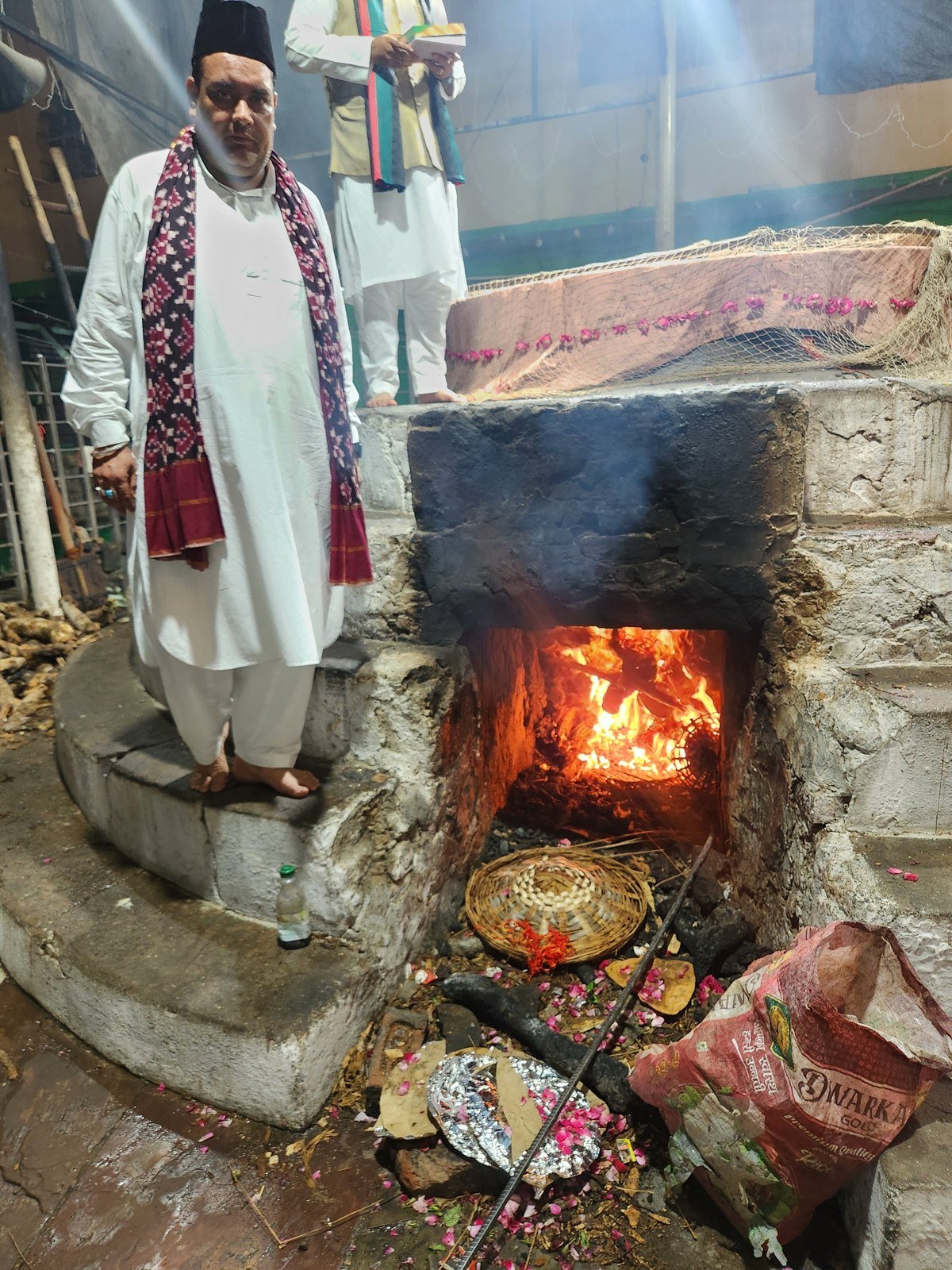 Burning wood in the masonry hearth beneath a deg cooking area